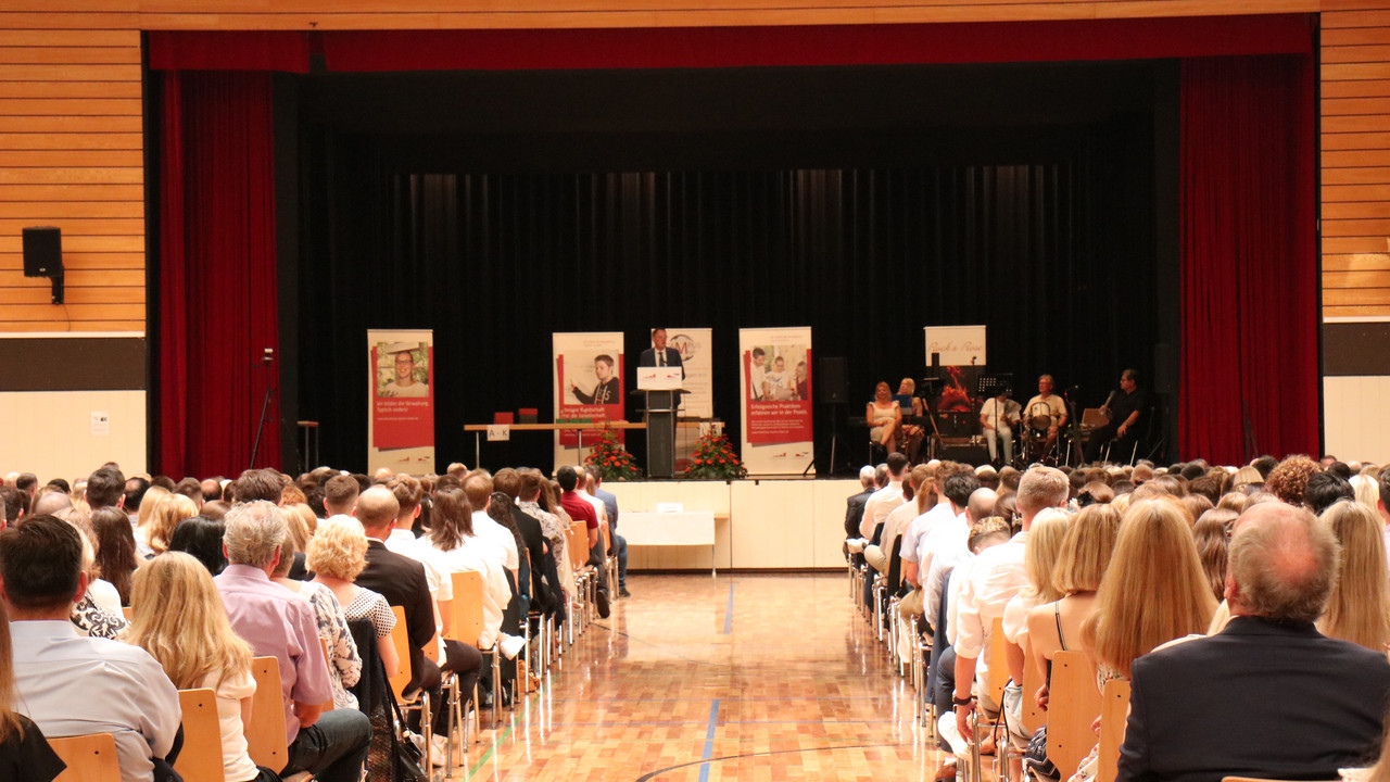 Foto in der Rheinlandhalle mit den Absolventinnen, Absolventen und Gästen während der Ansprache von Innenminister Michael Ebling.